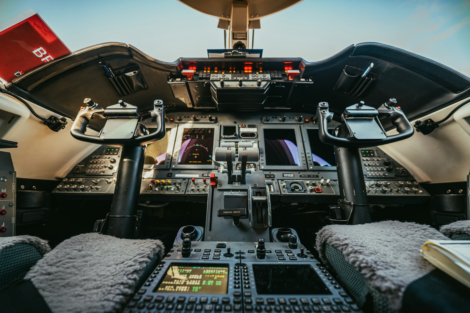 Bespoke private jet seating with hand-finished gold armrests